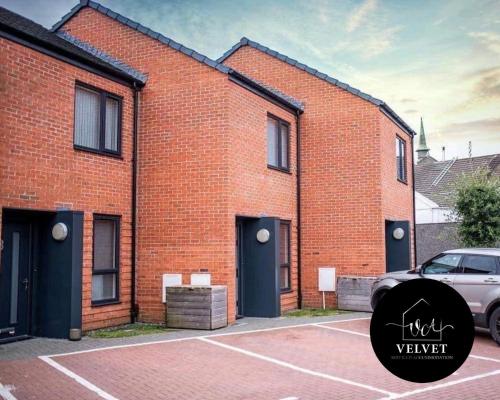 um edifício de tijolos com um carro estacionado em frente em 1 Bed House at Velvet Serviced Accommodation Swansea with Free Parking & WiFi - SA1 em Swansea