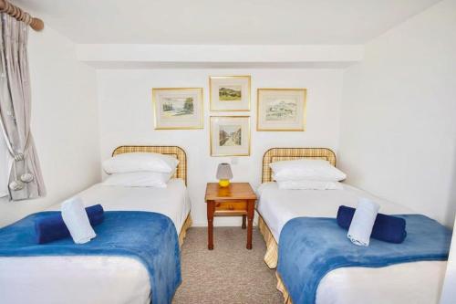 twee eenpersoonsbedden in een kamer met een tafel bij Mulberry Cottage in Cowes