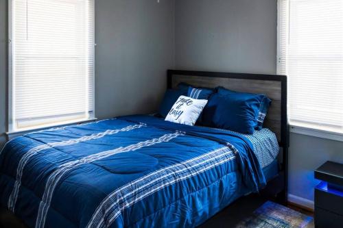 a bedroom with a bed with blue sheets and pillows at The Harperwood's Haven in Harper Woods