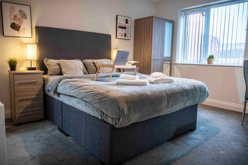 a bedroom with a large bed with a laptop on it at 1 Bed House at Velvet Serviced Accommodation Swansea with Free Parking & WiFi - SA1 in Swansea