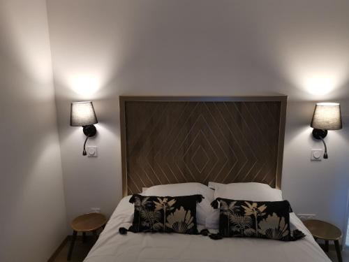 a bedroom with a large bed with two lamps at Logis Le Relais du Chapeau Rouge in Saint Loup Lamaire