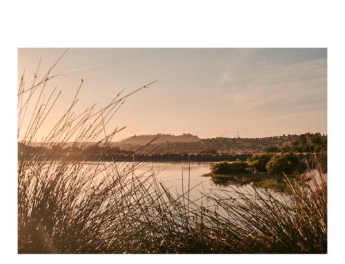 a view of a body of water with mountains in the background at L'AND Vineyards - Relais & Châteaux in Montemor-o-Novo