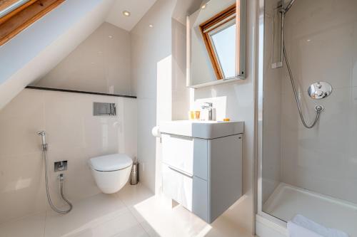 a white bathroom with a toilet and a shower at Manson Place in London