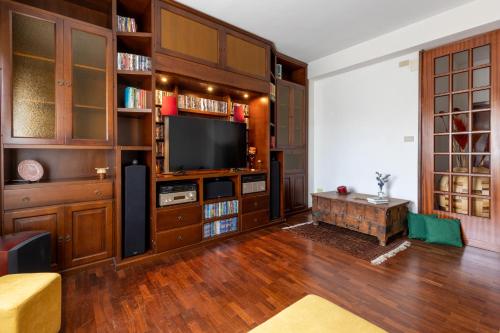 sala de estar con armarios de madera y TV de pantalla plana en Casa Kirribilli Palermo en Palermo