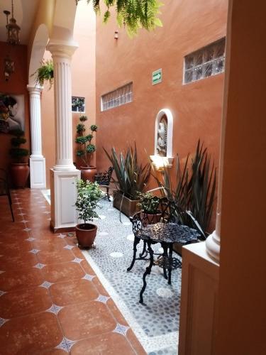 a hallway with benches and plants in a building at Hotel Victorina de Híjar in Tequila