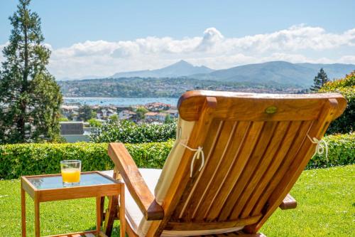 a wooden chair with a glass of orange juice on a table at Bista Eder Hotel & Lodge in Hondarribia