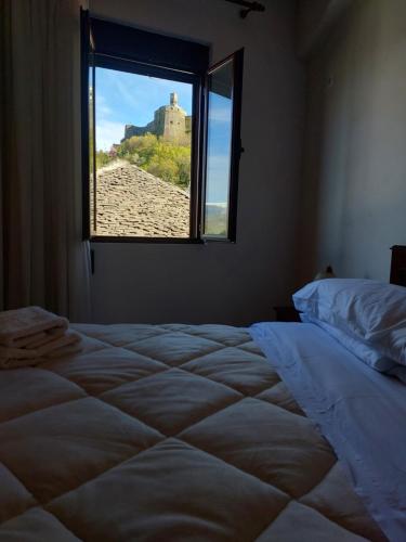 a bedroom with a large bed with a window at GEORGE's VILLA in Gjirokastër