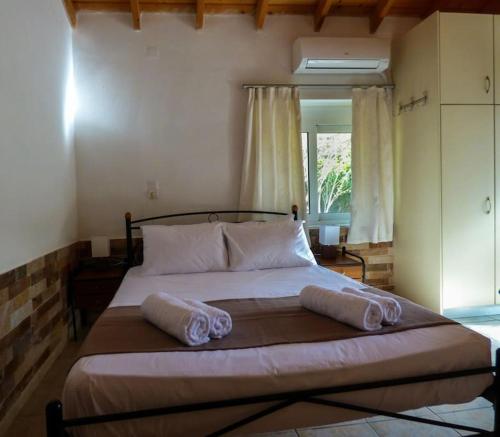 a bedroom with a large bed with two pillows on it at Garden house No1 in Plomari