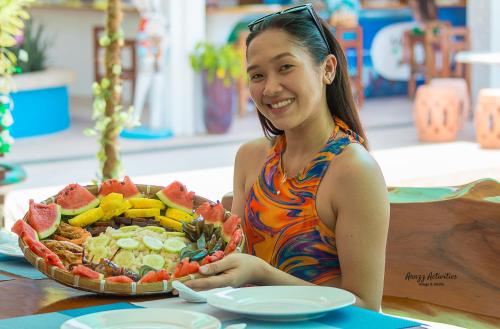 a woman sitting at a table with a tray of food at Moalboal Tropics in Moalboal