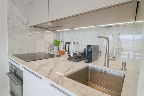 uma cozinha com um lavatório e uma bancada em LE MEDITERRANEEN - Renovated apartment with sea view em Cannes