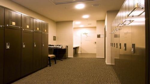 a hallway with lockers in a locker room at Dormy Inn Nagasaki Shinchichukagai in Nagasaki