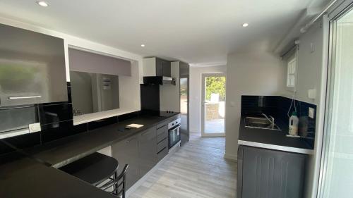 - une cuisine avec des comptoirs en noir et blanc et un évier dans l'établissement Appartement Palmier, à Sanary-sur-Mer