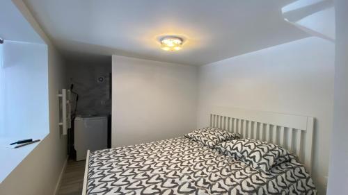 une chambre avec un lit dans une pièce blanche dans l'établissement Appartement Palmier, à Sanary-sur-Mer