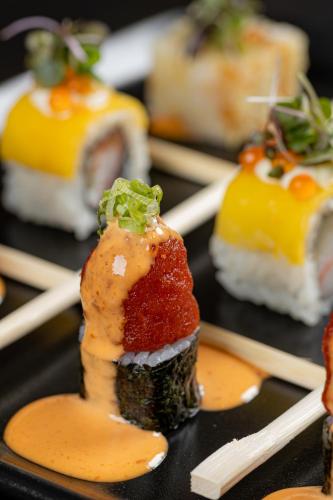 a plate of sushi with chopsticks on top of it at Dusit Thani Dubai in Dubai