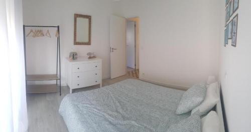 sypialnia z łóżkiem, komodą i lustrem w obiekcie VieiraMar w mieście Praia da Vieira