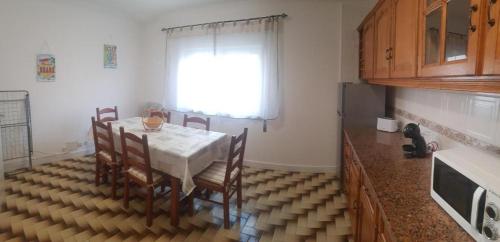kuchnia ze stołem i krzesłami oraz oknem w obiekcie VieiraMar w mieście Praia da Vieira
