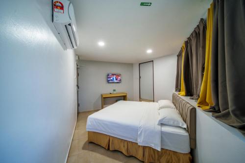 Habitación pequeña con cama y TV. en Hotel Uptown Semenyih, en Semenyih