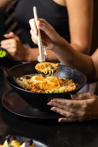 a person holding a plate of food with a bowl of food at Dusit Thani Dubai in Dubai