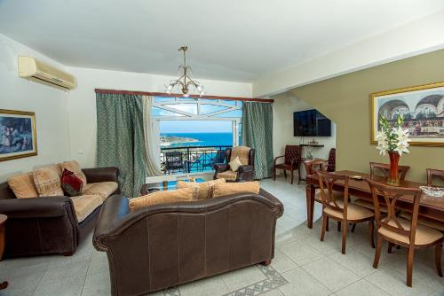 uma sala de estar com um sofá, uma mesa e cadeiras em Vasiliki Island view house em Agios Nikolaos