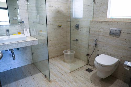 Un baño con ducha, inodoro y lavabo. en Rosetum Anjuna Goa, en Anjuna