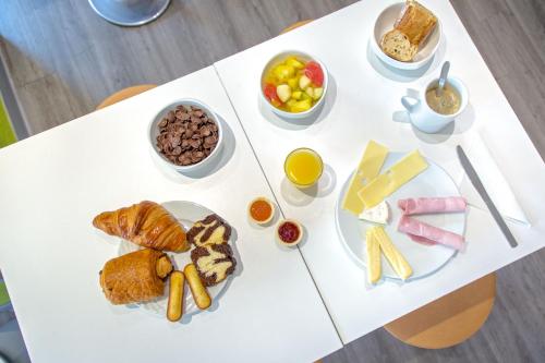 a white table with plates of food on it at Ibis Budget Fréjus Capitou in Fréjus