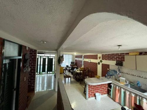 a kitchen and dining room with a brick wall at Casa con piscina para descanso in Chachagüí