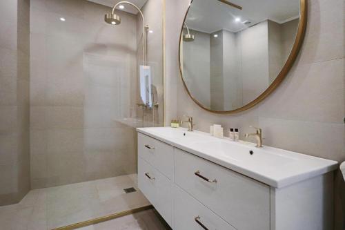 łazienka z białą umywalką i lustrem w obiekcie LE SUQUET - Bright renovated and spacious apartment w Cannes