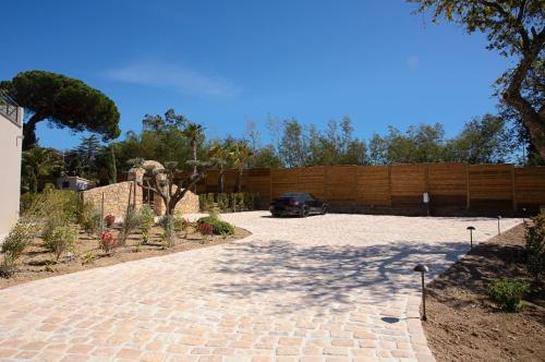 a driveway with a car parked in a backyard at Villa Ryx avec piscine in Grimaud