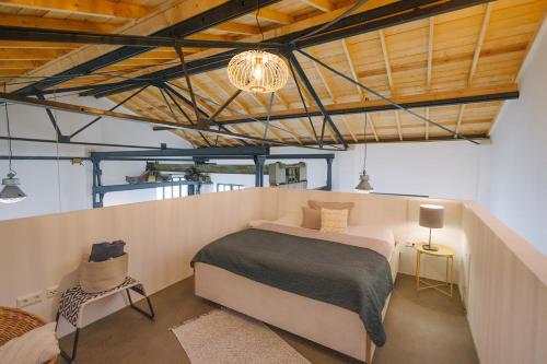 a bedroom with a bed and a chandelier at ElbQuartier Apartments Magdeburg 'Fabrik61' in Magdeburg