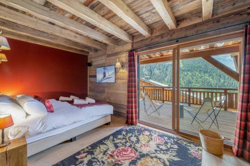 a bedroom with a bed and a balcony at Ikaria - Chalet - BO Immobilier in Châtel
