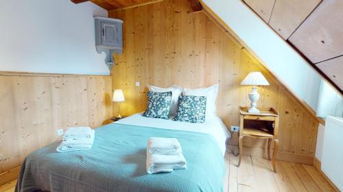a bedroom with a bed with towels on it at Les Appartements Manala - Turckheim in Turckheim