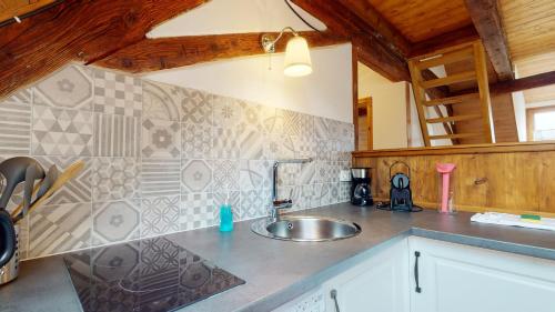 uma cozinha com um lavatório e uma bancada em Les Appartements Manala - Turckheim em Turckheim
