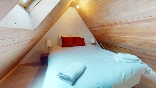 a bedroom with a bed in a wooden wall at Les Appartements Manala - Turckheim in Turckheim