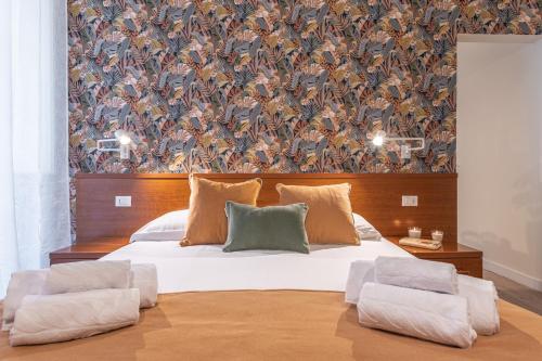 una camera da letto con un grande letto bianco e carta da parati di Vittoria Garden Suites a Roma