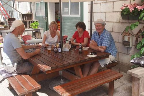 a group of people sitting at a picnic table at Vakantiechalet Jonagold 4 personen in Hengstdijk