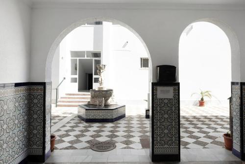 pokój z dwoma łukami i fontanną w budynku w obiekcie Apartamento Atlántico w mieście Barbate