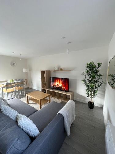 a living room with a couch and a fireplace at 2 Bedroom City Centre Apartment in Hemel Hempstead in Hemel Hempstead