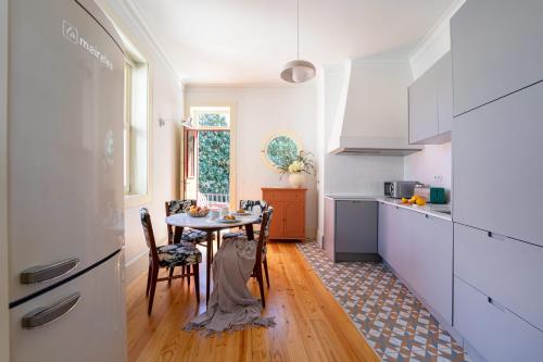 a kitchen with a table and chairs in a kitchen at Entre Ruas Apartments in Coimbra
