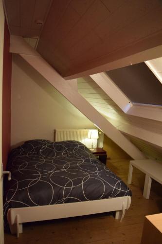 a bedroom with a bed in a attic at La Villa Blanche in Houffalize