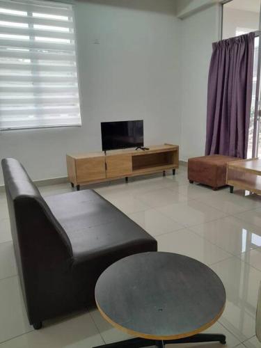 a living room with a couch and a table at Simple Home Taiping 简居 @ Suria Aman in Kamunting