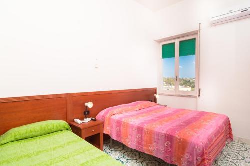 a bedroom with two beds and a window at Hotel Riviera in Procida
