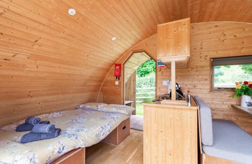 a bedroom with a bed in a wooden cabin at 68 Degrees West Glamping in Brecon