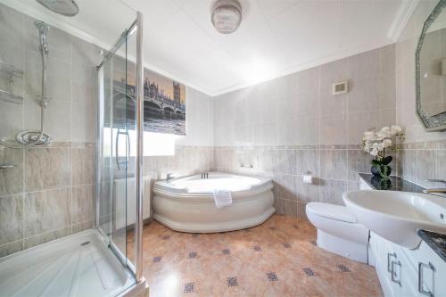 een badkamer met een bad, een wastafel en een douche bij *105* Setup for your most relaxed & amazing stay + Free Parking + Free Fast WiFi * in Batley