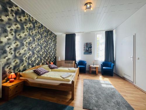 1 dormitorio con 1 cama y 2 sillas azules en Hotel My My en Lahnstein