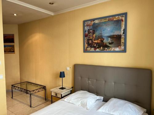 Un dormitorio con una cama y un cuadro en la pared. en Village Croisette, en Cannes