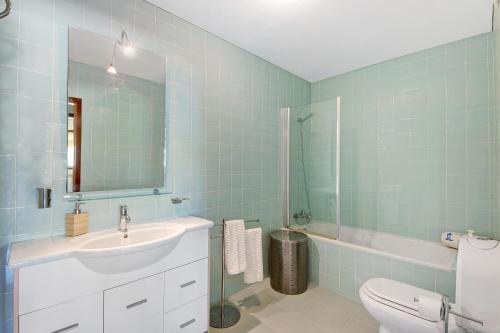 La salle de bains est pourvue d'un lavabo, de toilettes et d'un miroir. dans l'établissement Cantinho da Praia da Barra, à Gafanha da Nazaré