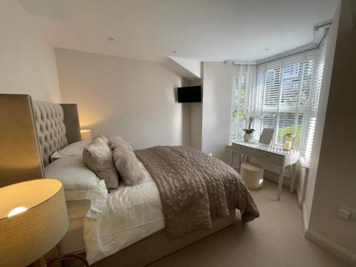a bedroom with a bed and a desk and a window at Heather Mere Cottage, Bowness-on-Windermere in Bowness-on-Windermere