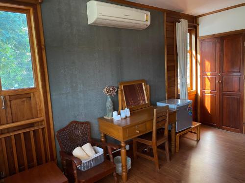 a desk with a mirror and a chair in a room at Tha Ma-O Bouteak homestay - ท่ามะโอบูทีคโฮมสเตย์ - pet friendly in Lampang