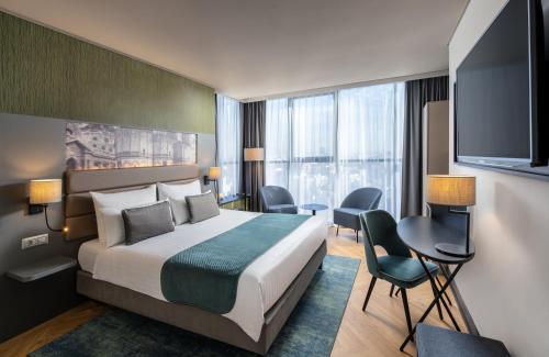 ブカレストにあるLeonardo Hotel Bucharest City Centerのベッド1台、薄型テレビが備わるホテルルームです。