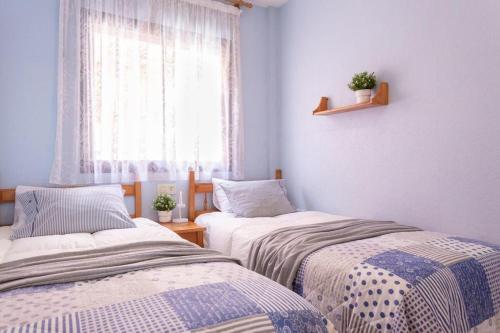 deux lits dans une chambre avec fenêtre dans l'établissement Bonaire, à L'Escala